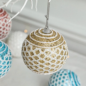 Glittery gold Christmas ball ornament with white mesh pattern and hanging string
