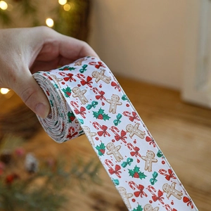 White Christmas ribbon roll with gingerbread man and candy cane patterns for gift wrapping