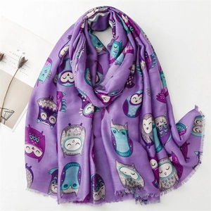 Detail of purple cotton linen scarf featuring colorful owl patterns and fringe edges