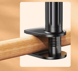 Detail of a black metal G-clamp bracket securely attached to a textured wooden pole