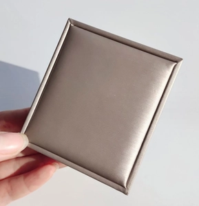 Detailed view of rectangular jewelry gift box with champagne satin textured surface