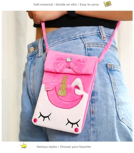 Detail of plush unicorn crossbody bag with pink bow, golden horn and crystal accent