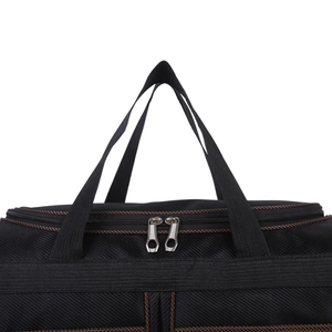 Detail of reinforced webbing handle and dual metal zippers on black nylon travel bag