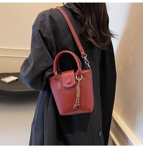 Rear view of a burgundy leather bucket bag with chain strap and knot detail