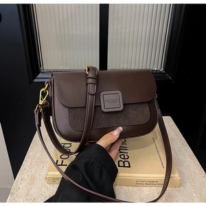 Detail of vintage dark brown crossbody bag featuring mixed leather texture and metal buckle