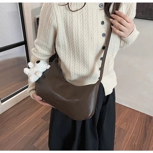 Detailed view of brown PU leather hobo bag with a cute white bear plush charm accessory