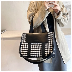 Mirror selfie showing the houndstooth tote bag with black leather flap and shoulder strap