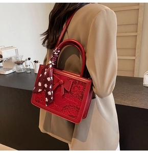 Side view of red Chinese-style bridal handbag with floral embroidery and bow decoration