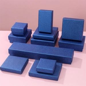 Detail view of navy blue textured jewelry gift boxes for rings and necklaces on pink background