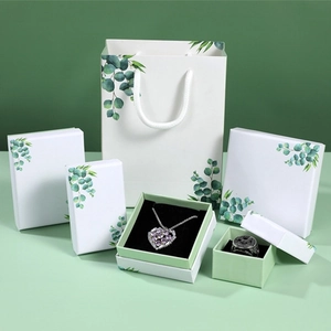 Detailed set of white jewelry boxes with fresh eucalyptus leaf prints and matching paper bag