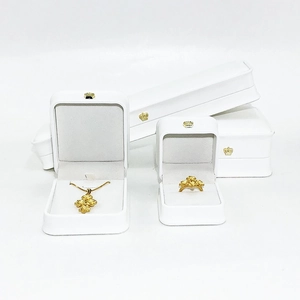 White jewelry gift boxes with gold crown logo featuring necklace and ring display