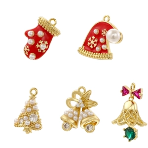 Detailed view of Christmas charms featuring enamel hats, bells, and pearl trees