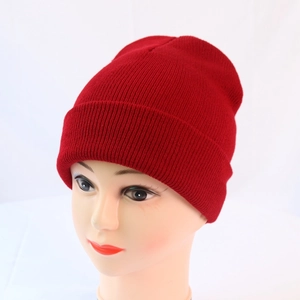 Detail of red knit beanie showing fine ribbed texture and folded cuff for winter warmth