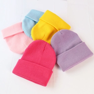 Detailed texture of colorful knitted beanies in pink, blue, yellow, and purple hues