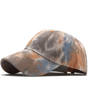 Detail view of cotton tie-dye baseball cap with orange and blue batik stitching pattern