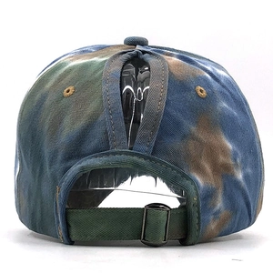 Detail view of the adjustable metal buckle and ponytail hole on tie-dye baseball cap