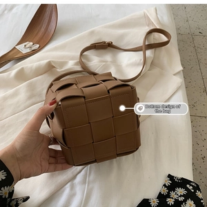 Detail showing the brown woven leather bag bottom and square grid texture craftsmanship