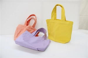 Detail view of colorful canvas lunch bags in yellow, purple, and orange pink fabric