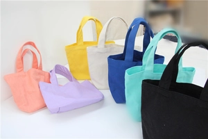 Detail showing various colorful canvas lunch bags in orange, purple, yellow, and blue