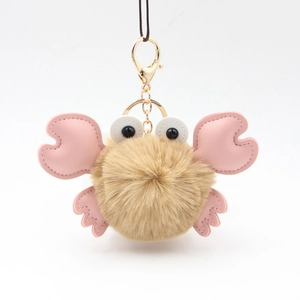 Close-up of cute beige plush crab keychain with pink PU leather claws and golden clasp