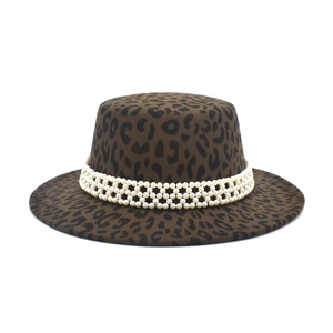 Detail of leopard print flat top wool hat featuring an intricate faux pearl woven band