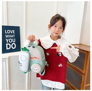 Detail of mint green toddler backpack with rabbit charm and carrot shaped pocket feature