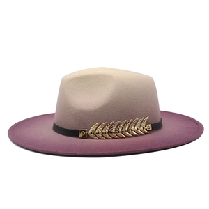 Detail of gradient fedora hat showing beige to purple wool felt and golden leaf buckle