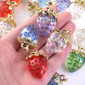 Detailed view of colorful strawberry charms in resin with gold metal leaves for DIY crafts