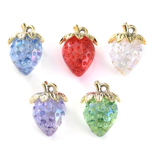 Detailed view of colorful strawberry charms with rhinestones and golden leaf accents
