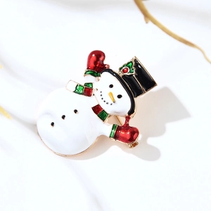 Cartoon snowman enamel brooch with red scarf and green hat on a white background