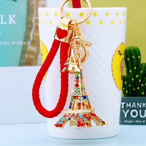 Detailed view of golden Eiffel Tower keychain with colorful rhinestones and red woven cord