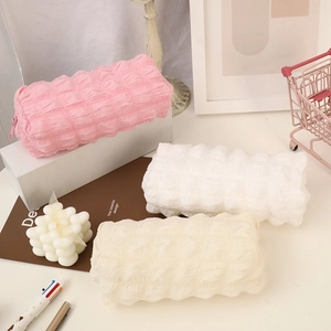 Large capacity puff texture pencil case in pink, white, and cream on an aesthetic desk