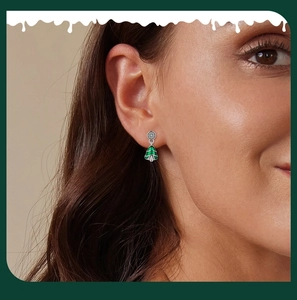 Close-up of a s925 sterling silver green Christmas tree stud earring on a model ear