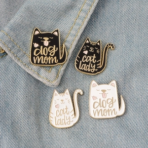 Cute enamel pet pins featuring Cat Lady and Dog Mom text on blue denim background