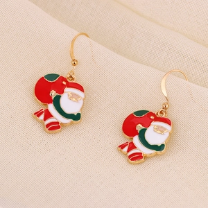 Close-up of Santa Claus drop earrings with festive red and green enamel on gold hooks