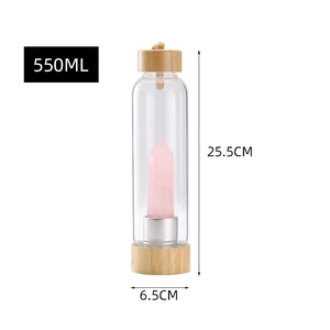 Detailed view of a 550ml glass water bottle with bamboo lid and pink crystal pillar