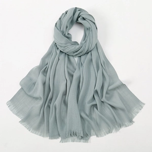 Close-up of light grey-green bamboo cotton scarf showing soft texture and raw edges