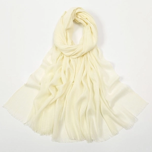 Detail view of cream slub cotton scarf showing breathable texture and fringe edges