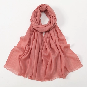 Detailed close-up of pink slub cotton scarf showing soft texture and tassel details