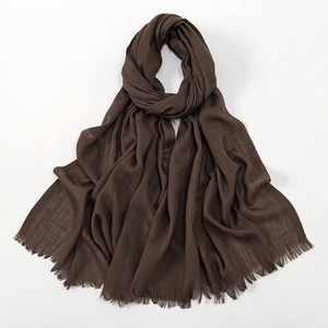 Close-up of dark brown slub cotton scarf showing soft texture and fringe edges