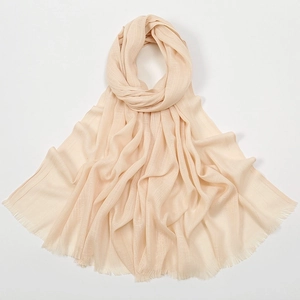 Detail of beige slub cotton scarf showing lightweight texture and fringe edges