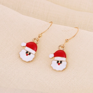 Macro detail of Christmas Santa Claus drop earrings with festive red and white enamel finish