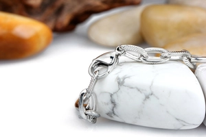 Macro shot of silver titanium steel bracelet link with lobster clasp and textured finish