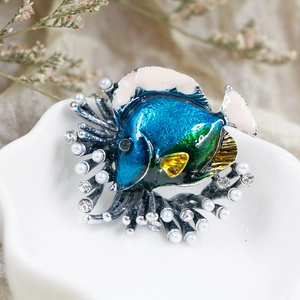Macro shot of tropical fish brooch featuring colorful enamel detail and faux pearls