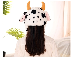 Detailed back view of plush cartoon cow hat with moving ears in soft faux fur material
