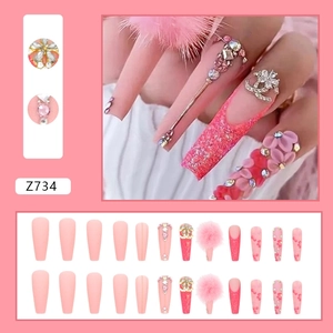 Long ballet pink press-on nails with rhinestones, fur balls, and metal chains