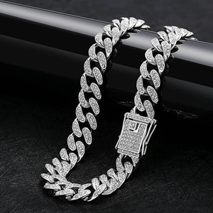 Close-up of iced-out silver Cuban link pet chain with rhinestones on black display