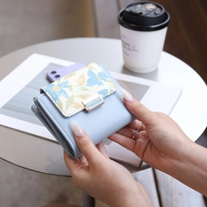 Close-up of light blue PU leather wallet featuring a yellow and blue floral flap pattern