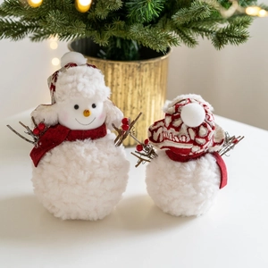 Plush knitted Christmas snowman figurines with red scarves on festive tabletop