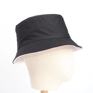 A detailed side view of a minimalist black bucket hat shown on a mannequin head